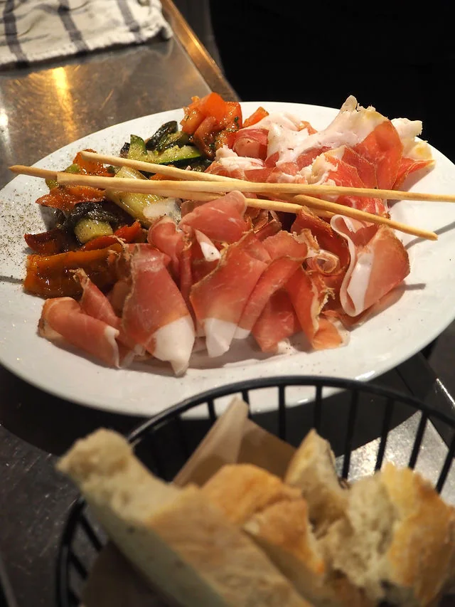 Antipasti mit Crudo, gegrilltem Gemüse und Grissini, dazu Brot