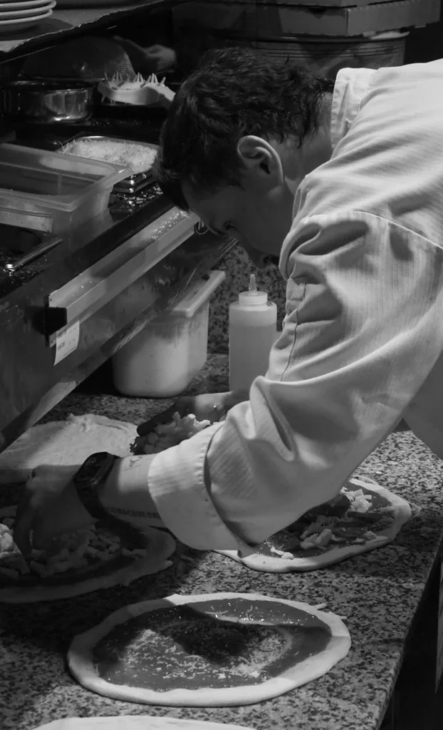 Pizzen werden in der Noras-Küche von Hand belegt