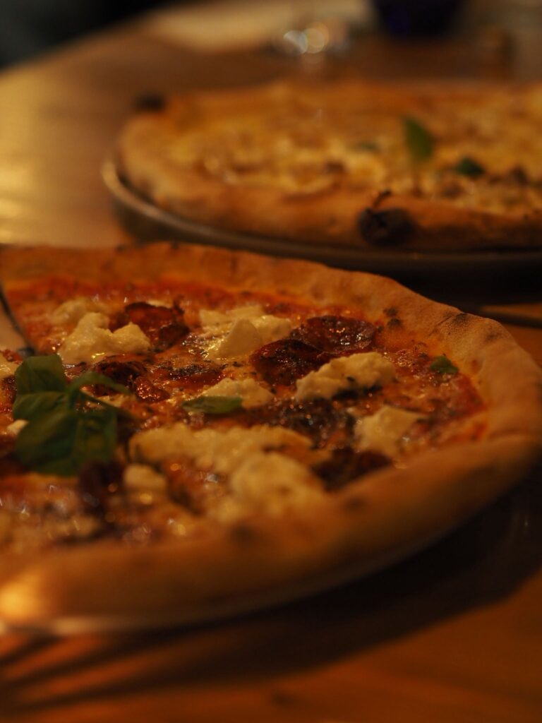 Pizza mit Ricotta, Salami und Basilikum